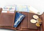 geöffnete Brieftasche mit Bargeld und Facebook- und Google Kärtchen